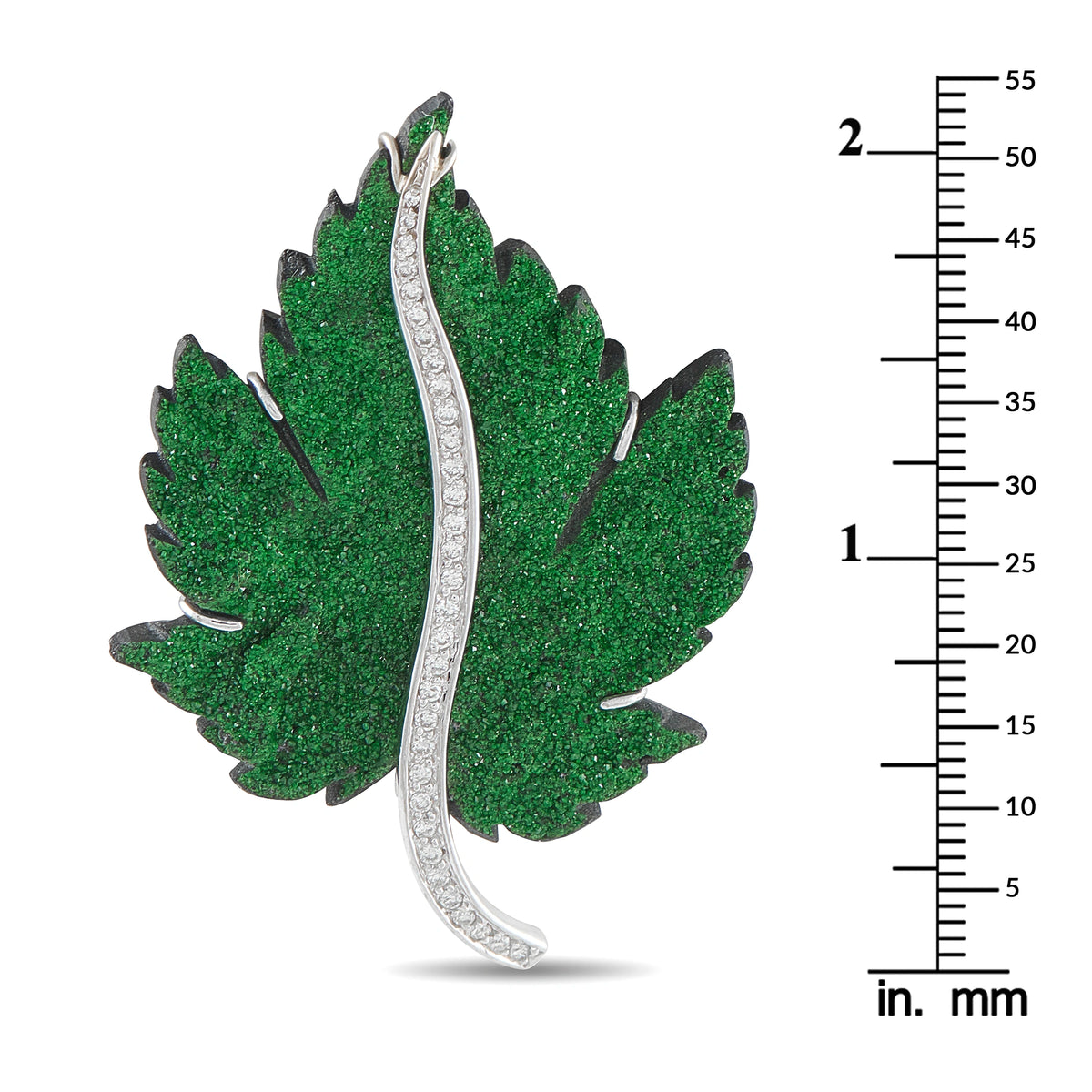 Green leaf brooch in white gold with diamond border, shown with inch/mm scale