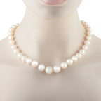 Round white pearl bead necklace on mannequin neckline, strand and clasp end visible