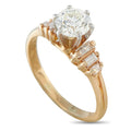 Round diamond engagement ring with baguette side stones, gold-toned band and prongs