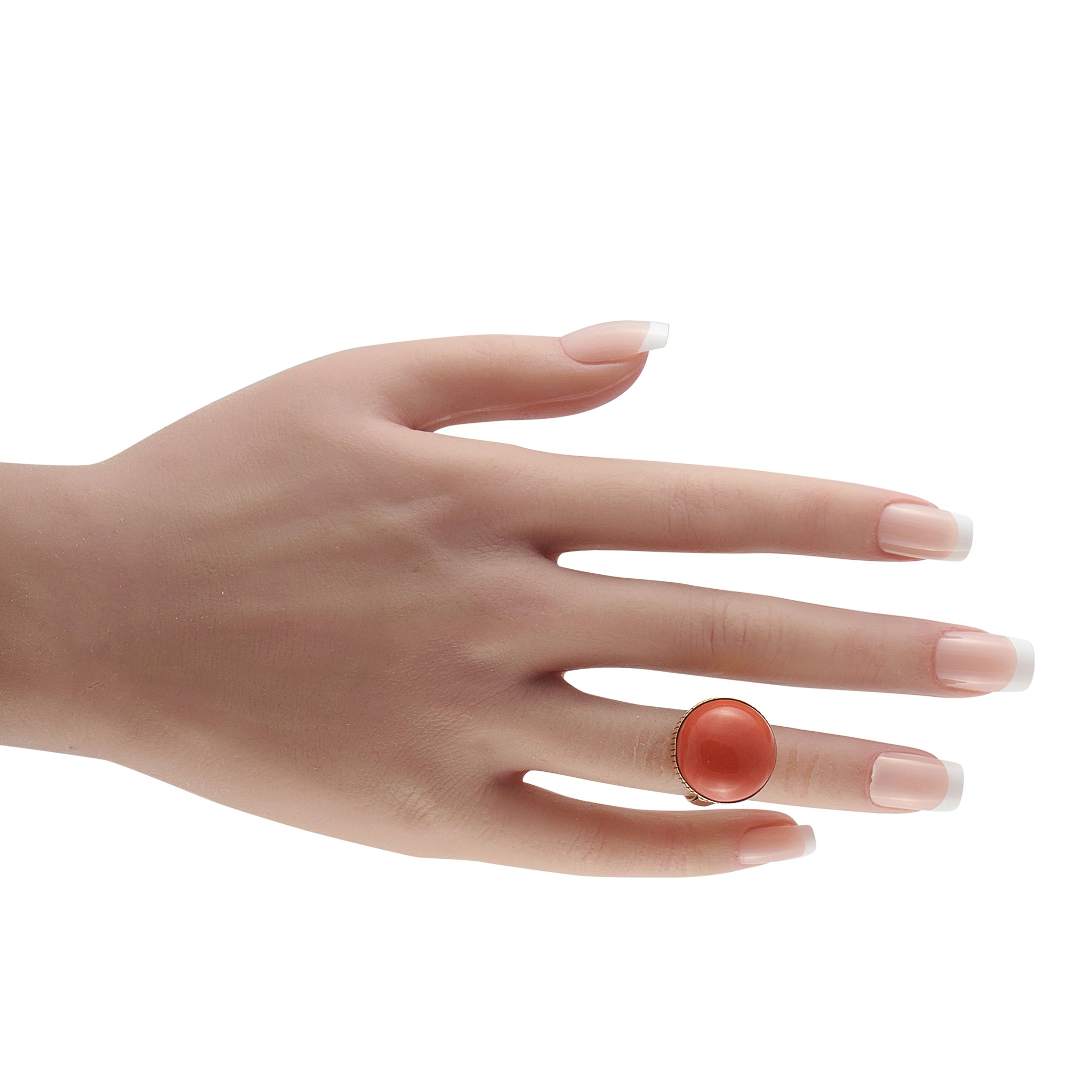 Coral red domed cabochon cocktail ring in 14K yellow gold on a hand