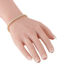 Yellow gold diamond tennis bracelet worn on hand