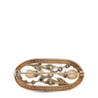 Oval gold-and-silver brooch with clasp bar, pin, and scrolling filigree