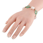 Rose quartz and green stone 14K yellow gold bracelet on wrist with link chain clasp