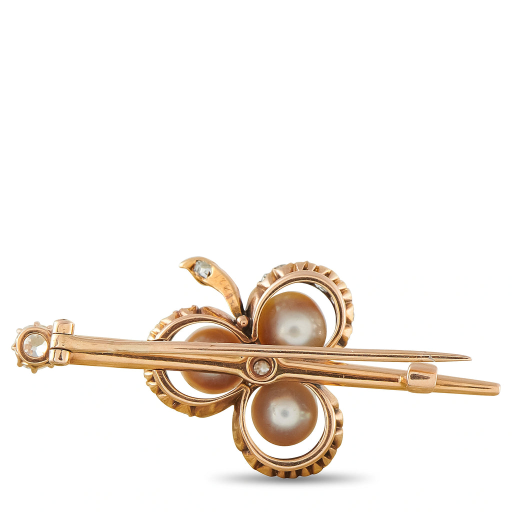 Rose gold bar brooch with three round pearls, diamond accents, and leaf-shaped setting