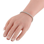 Diamond tennis bracelet in white gold with sparkling stones, worn on wrist