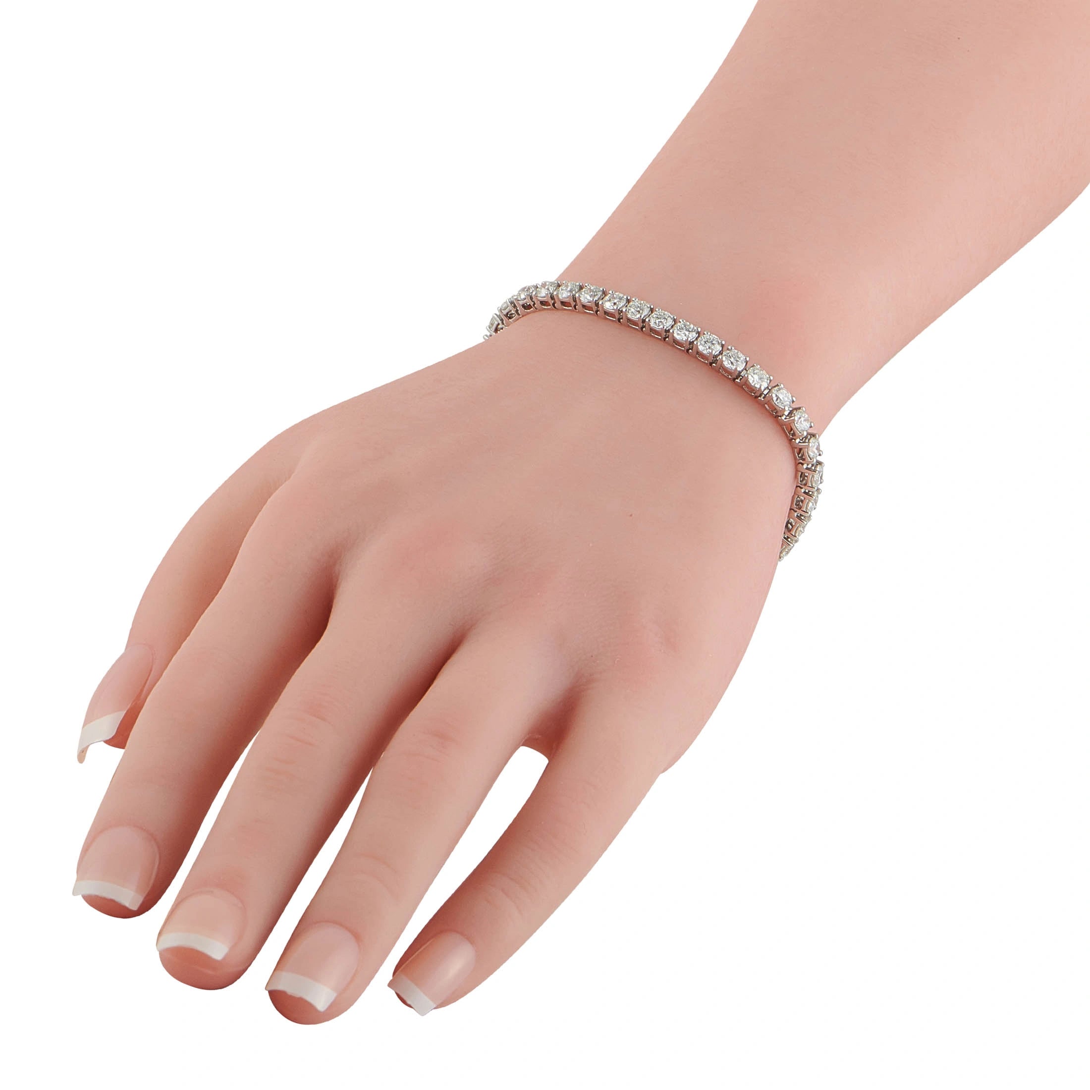 Diamond tennis bracelet in white gold with sparkling stones, worn on wrist