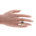 18K white gold diamond ring on hand, dark center stone with white halo and drop accents