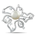 Diamond and pearl brooch with round pearl center and swirling diamond-studded frame