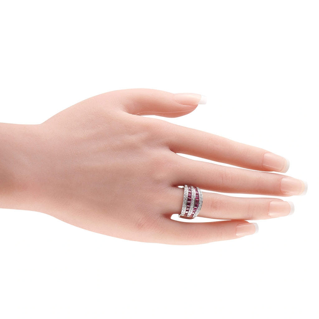 18K white gold ruby and diamond ring worn on a finger, with three gemstone rows