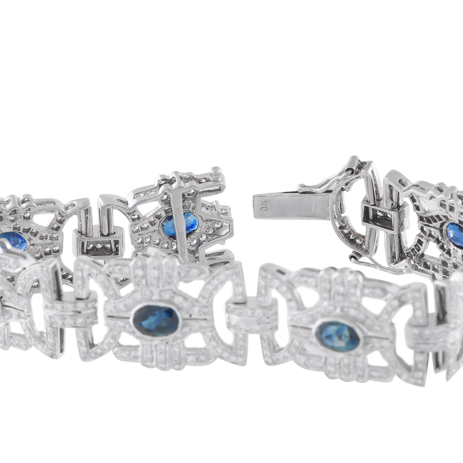 Close-up white gold bracelet clasp and links with blue sapphires and diamond details