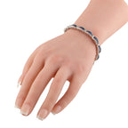White gold sapphire bracelet on wrist with blue baguette stones and diamond accents