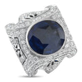 White gold sapphire and diamond ring with oval blue center stone and ornate side settings