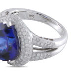 18K white gold ring close-up: blue tanzanite stone, diamond pave, 18K mark