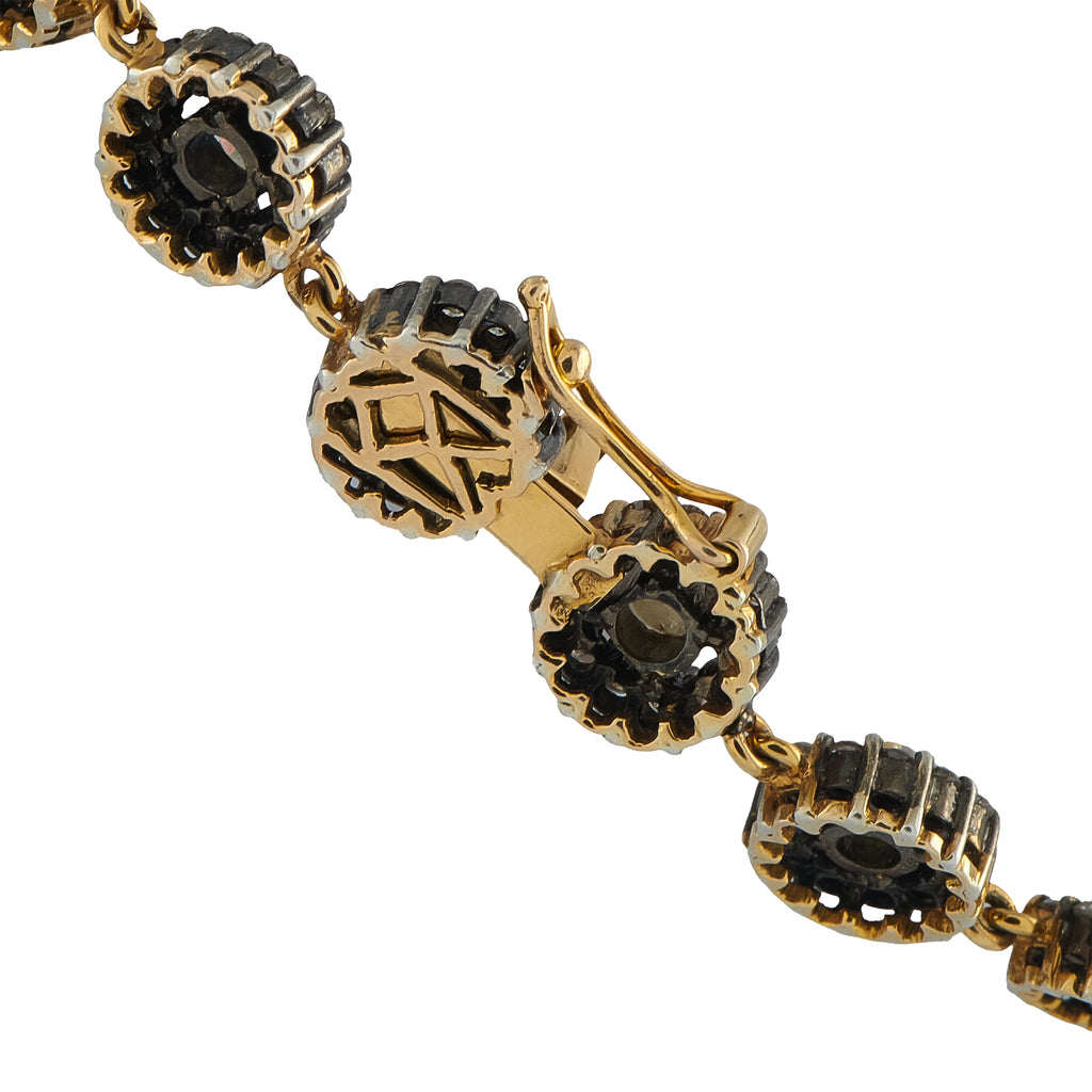 Yellow gold necklace chain links with dark oval centers and black stone accents
