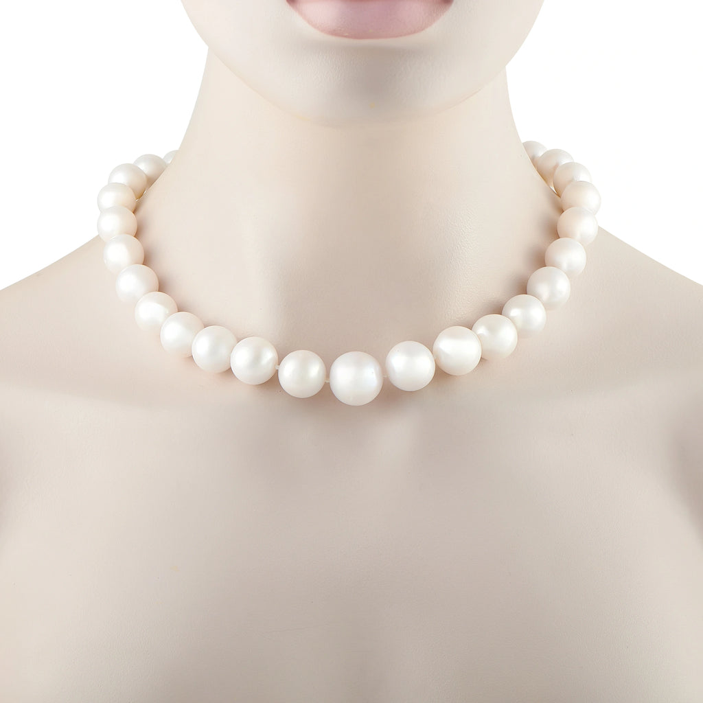 White pearl bead necklace with tightly spaced round pearls shown on the neckline
