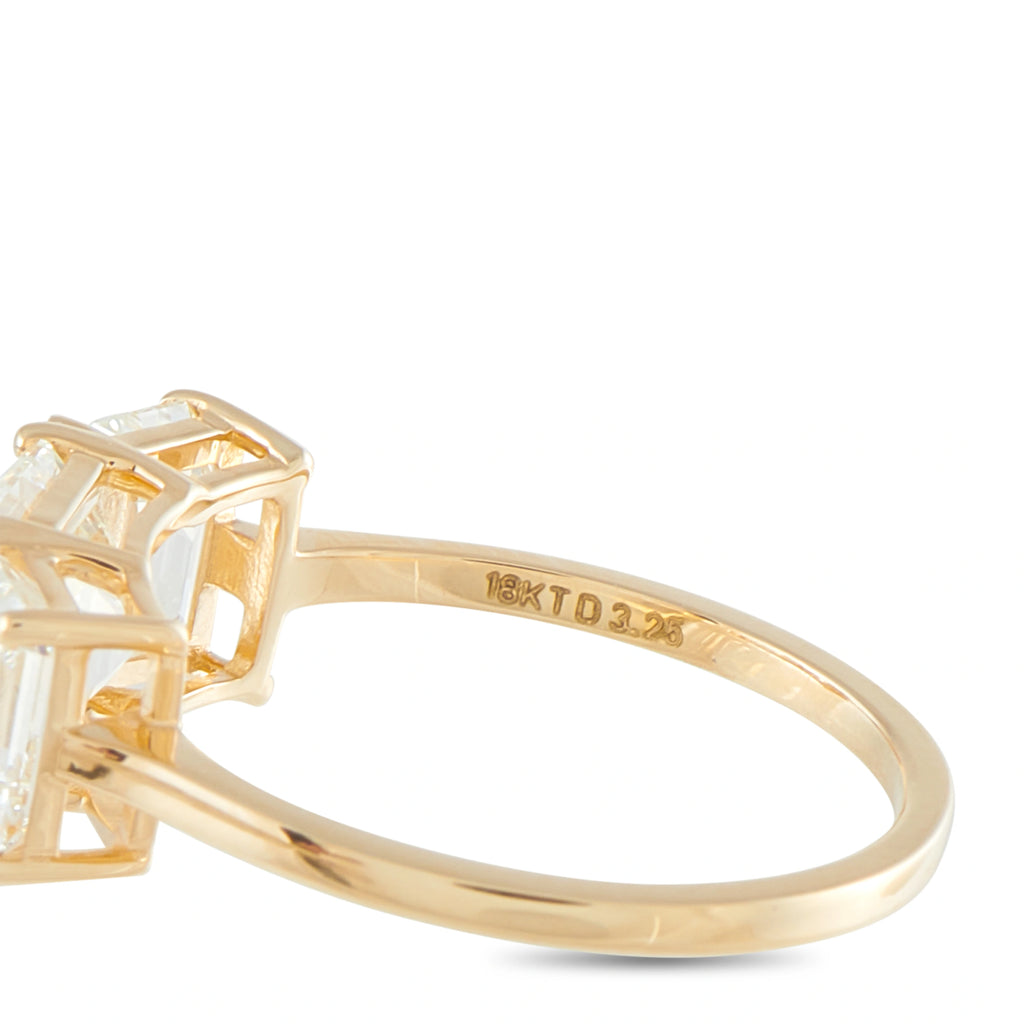 Yellow gold band with engraved hallmark near the three-stone diamond setting