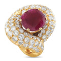 Yellow gold ring with oval ruby centerpiece and round diamond halo