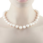 White pearl bead necklace with smooth round beads, close-up on neck