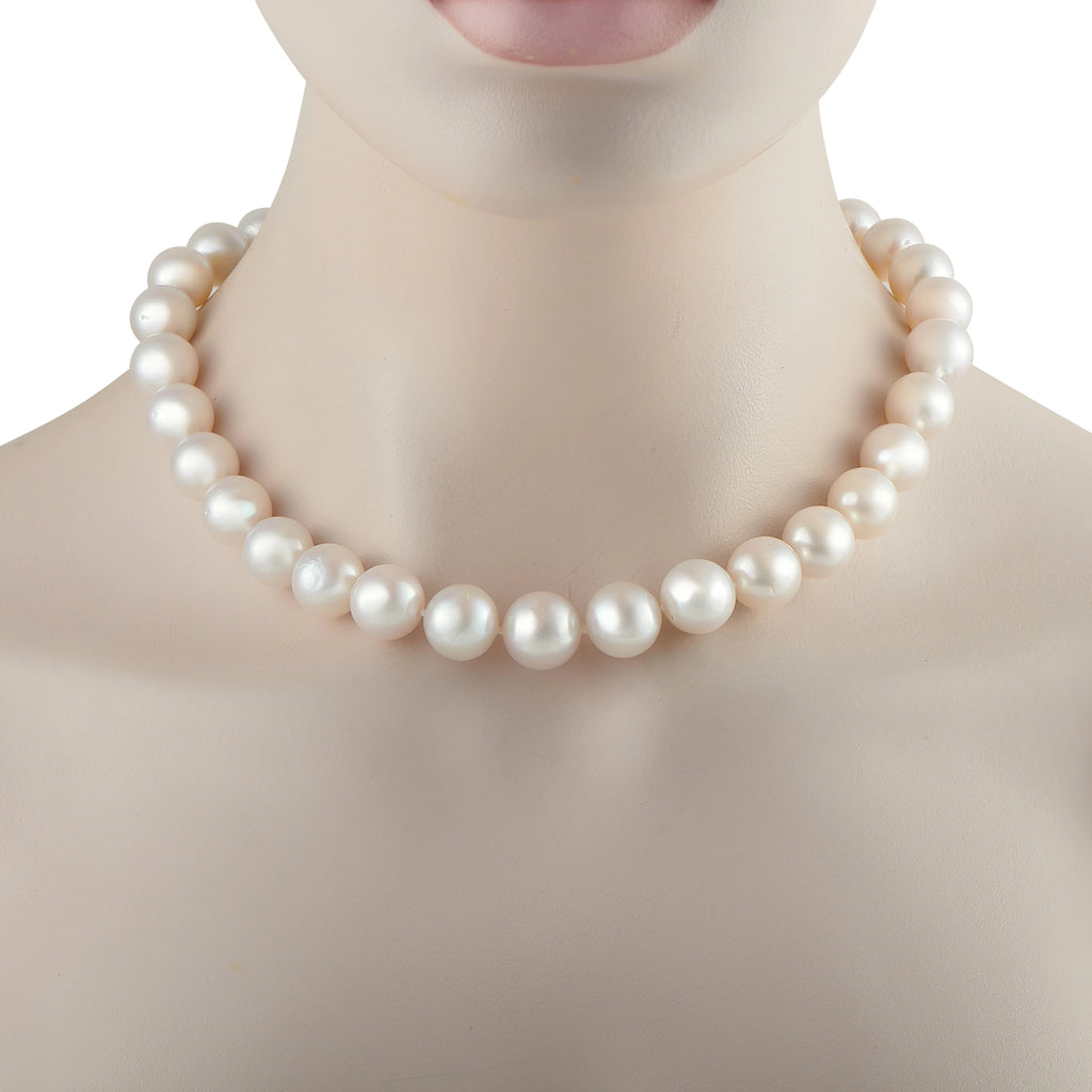 White pearl bead necklace close-up with rounded, glossy pearls