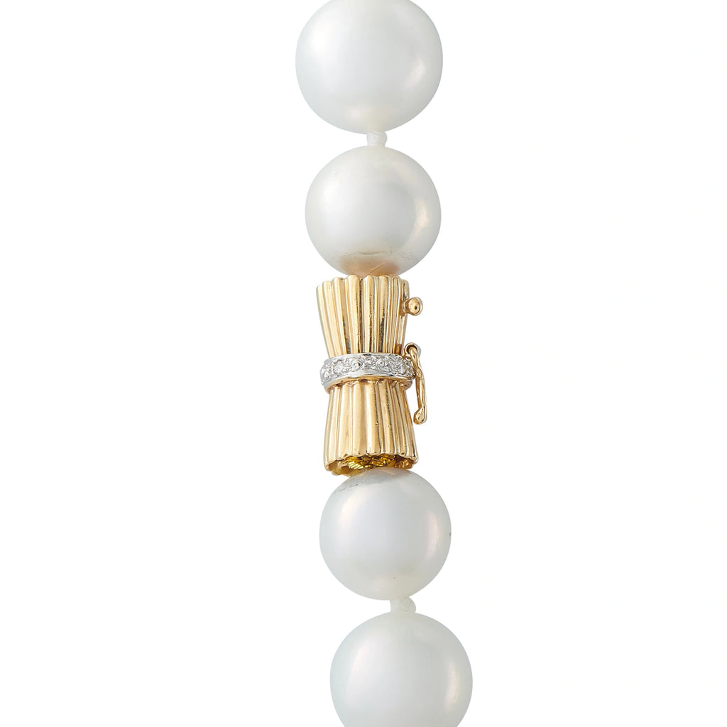 Gold clasp with pearl drops and crystal-like connector accents on necklace