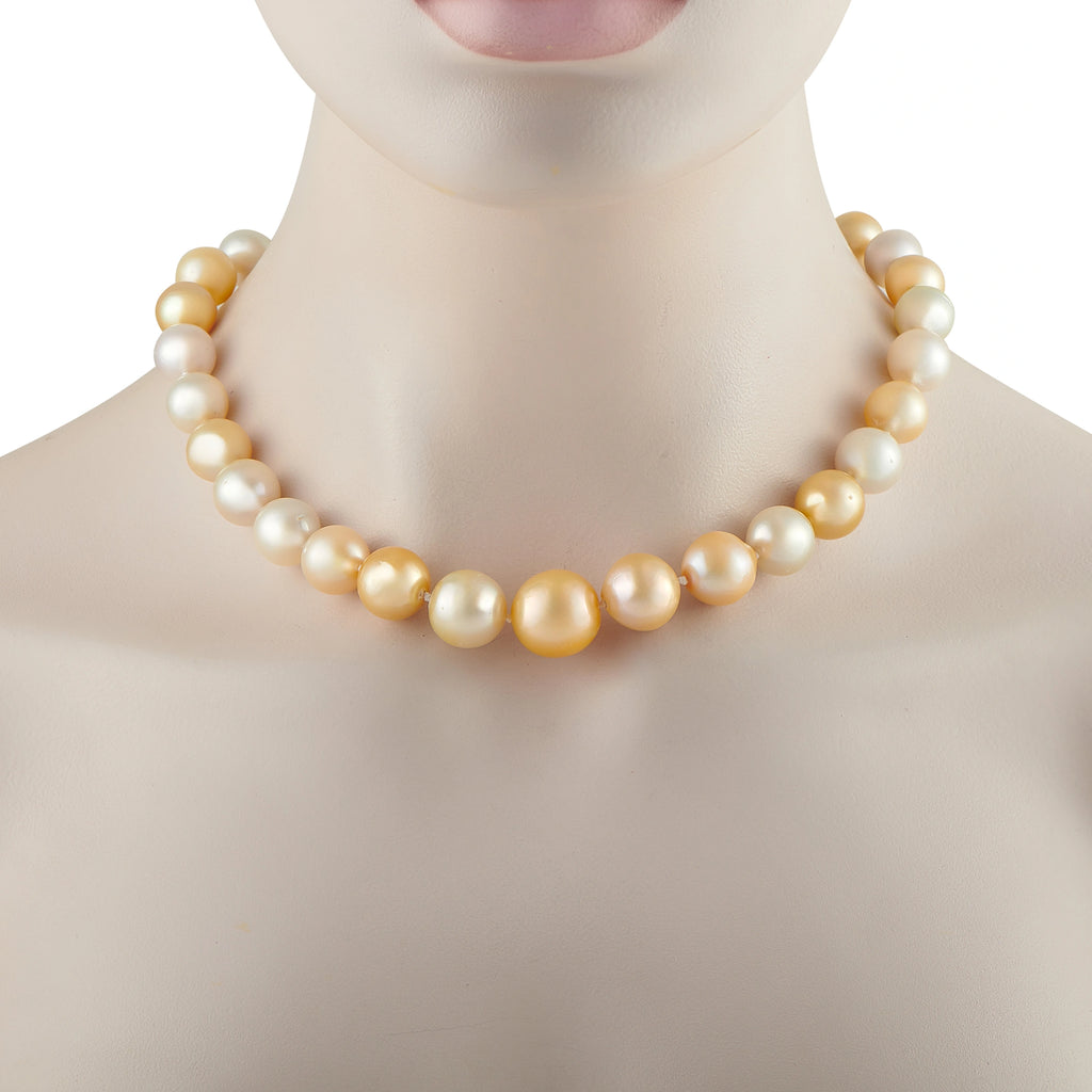 Pearl bead necklace with alternating white and gold-toned beads, close-up on collar