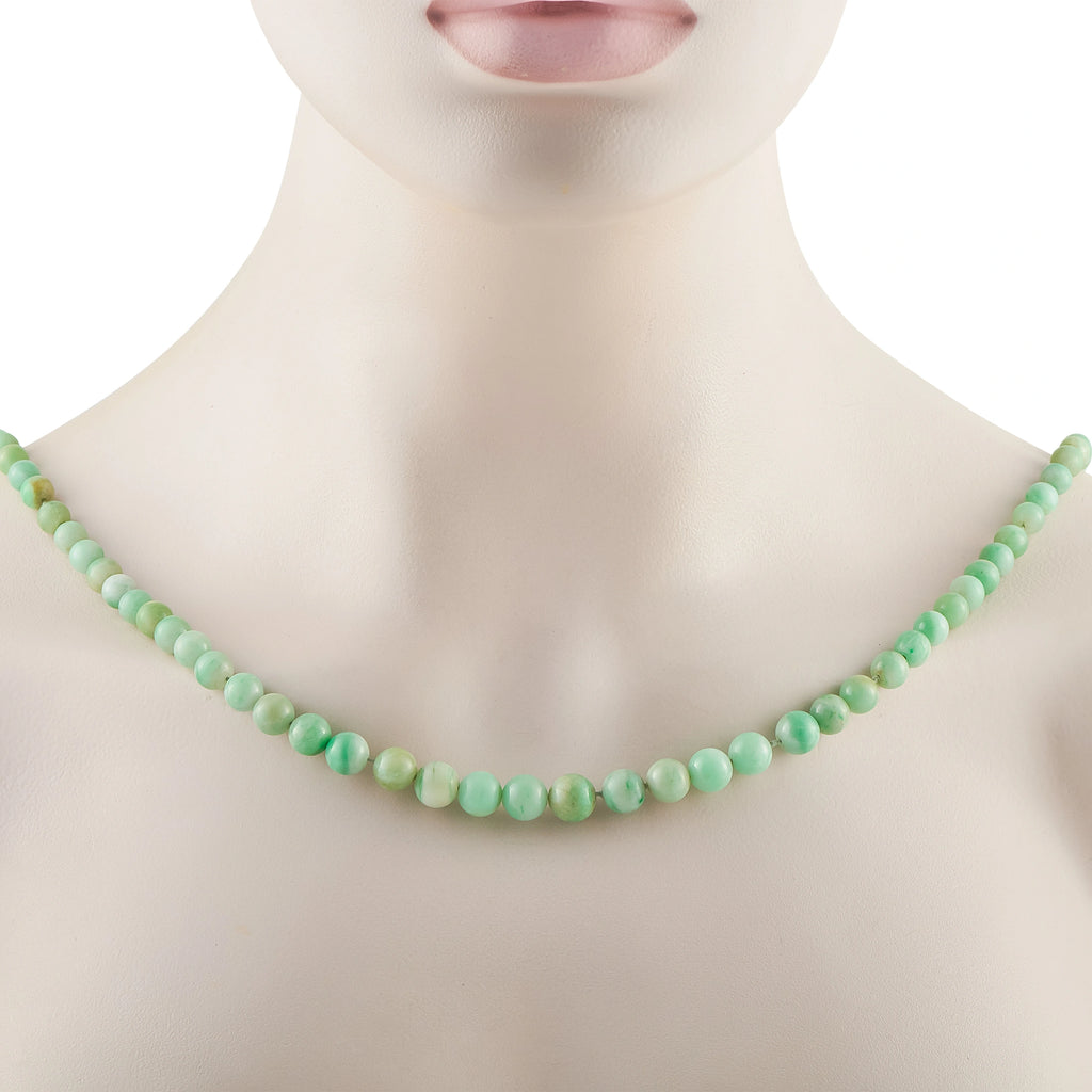Jade bead necklace on a model neck featuring smooth round green beads.