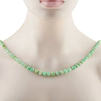 Jade bead necklace on a model neck featuring smooth round green beads.