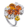 Platinum and 18K white gold ring with orange and yellow gemstones, framed by diamonds