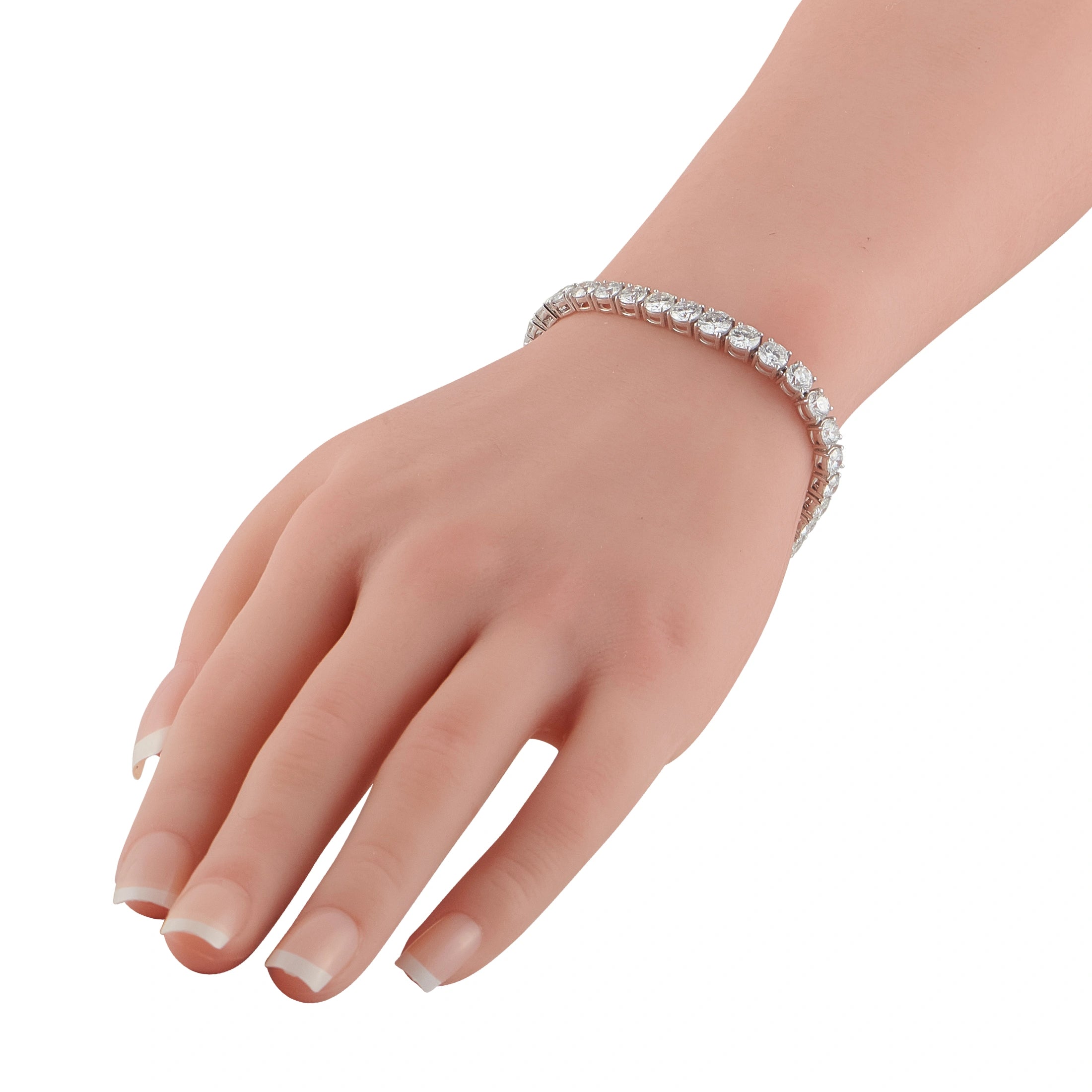 Diamond tennis bracelet on wrist, round stones set in platinum-colored metal