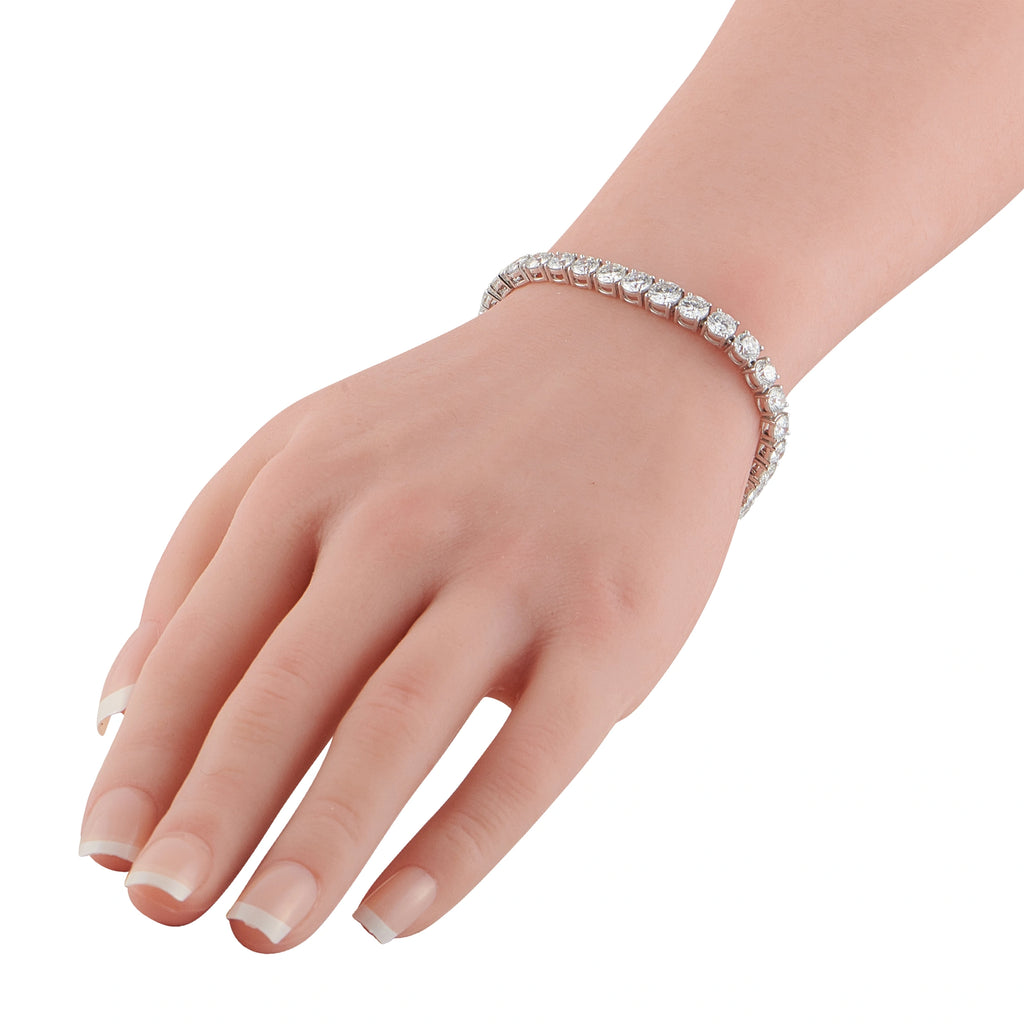 Diamond tennis bracelet on wrist with sparkling round stones in platinum setting