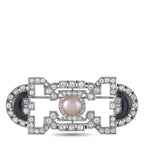 Art Deco brooch with pearl center, onyx insets, and diamond-like geometric frame
