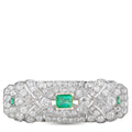 Art Deco diamond brooch with emerald-green square center and small side emeralds