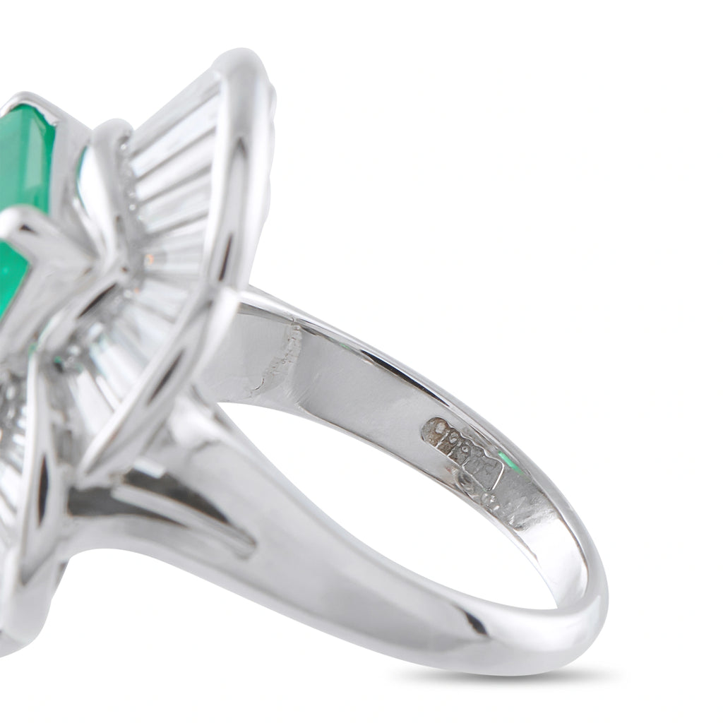 Platinum ballerina ring close-up of band, prongs, and emerald-cut green gemstone