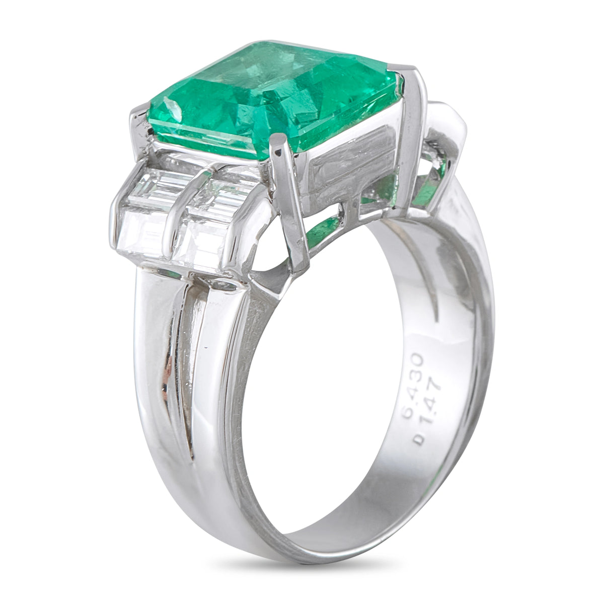 Platinum ring with emerald-cut green gemstone and baguette diamonds in stepped setting