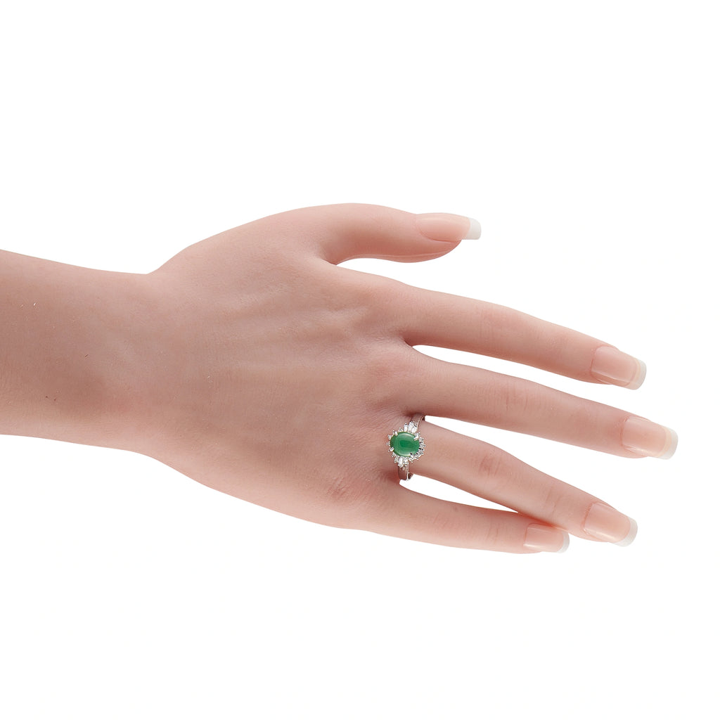Green jade and diamond halo ring on hand; oval center stone with prong setting