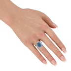 Platinum ring with blue-black opal cabochon and diamond border on hand