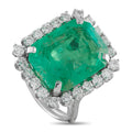 Platinum ring with emerald-cut green gemstone and diamond halo, side prongs