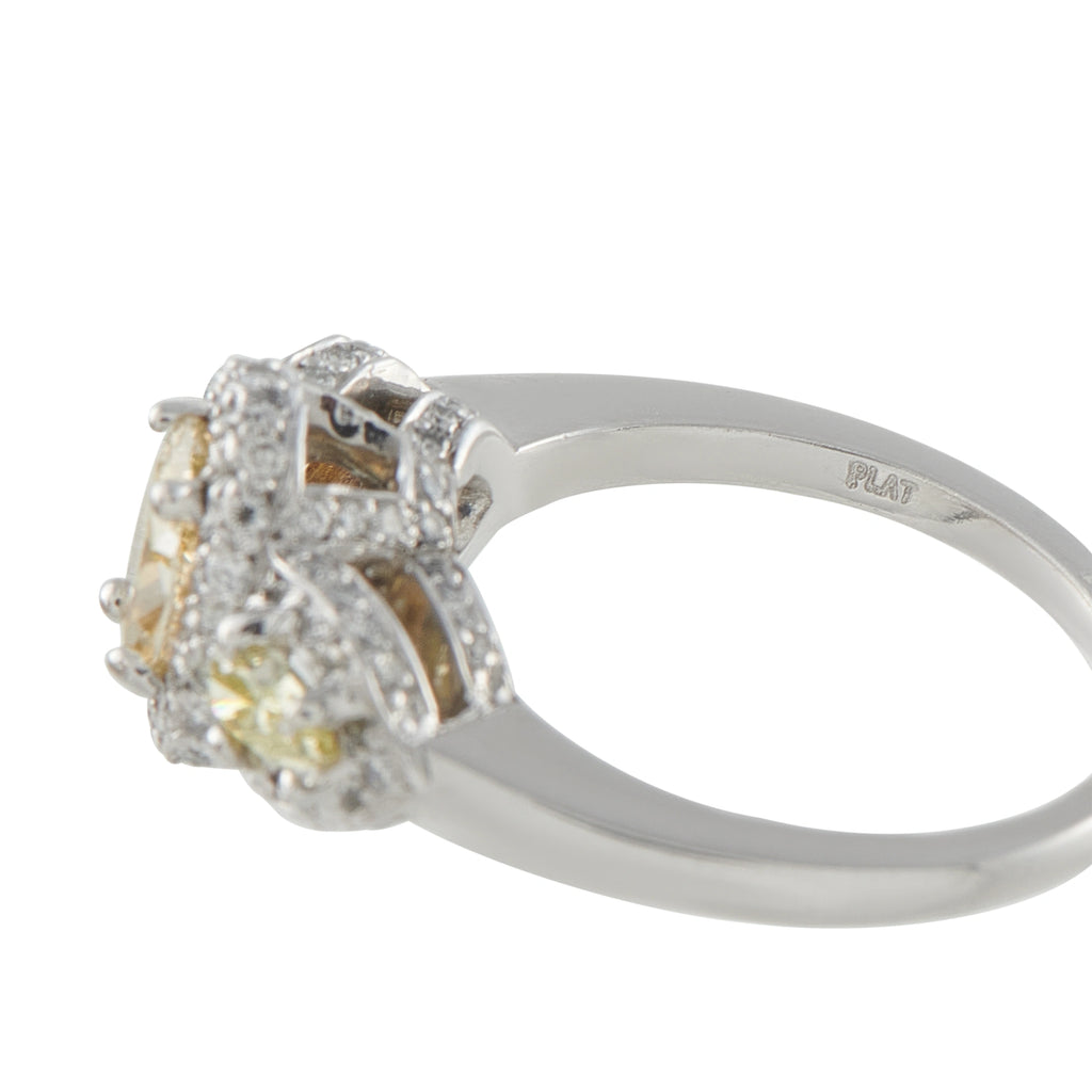 Platinum diamond halo three-stone ring with large oval yellow center and side stones; prong set