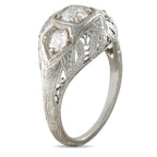 Platinum three-stone diamond ring with leaf motif engraving and domed settings