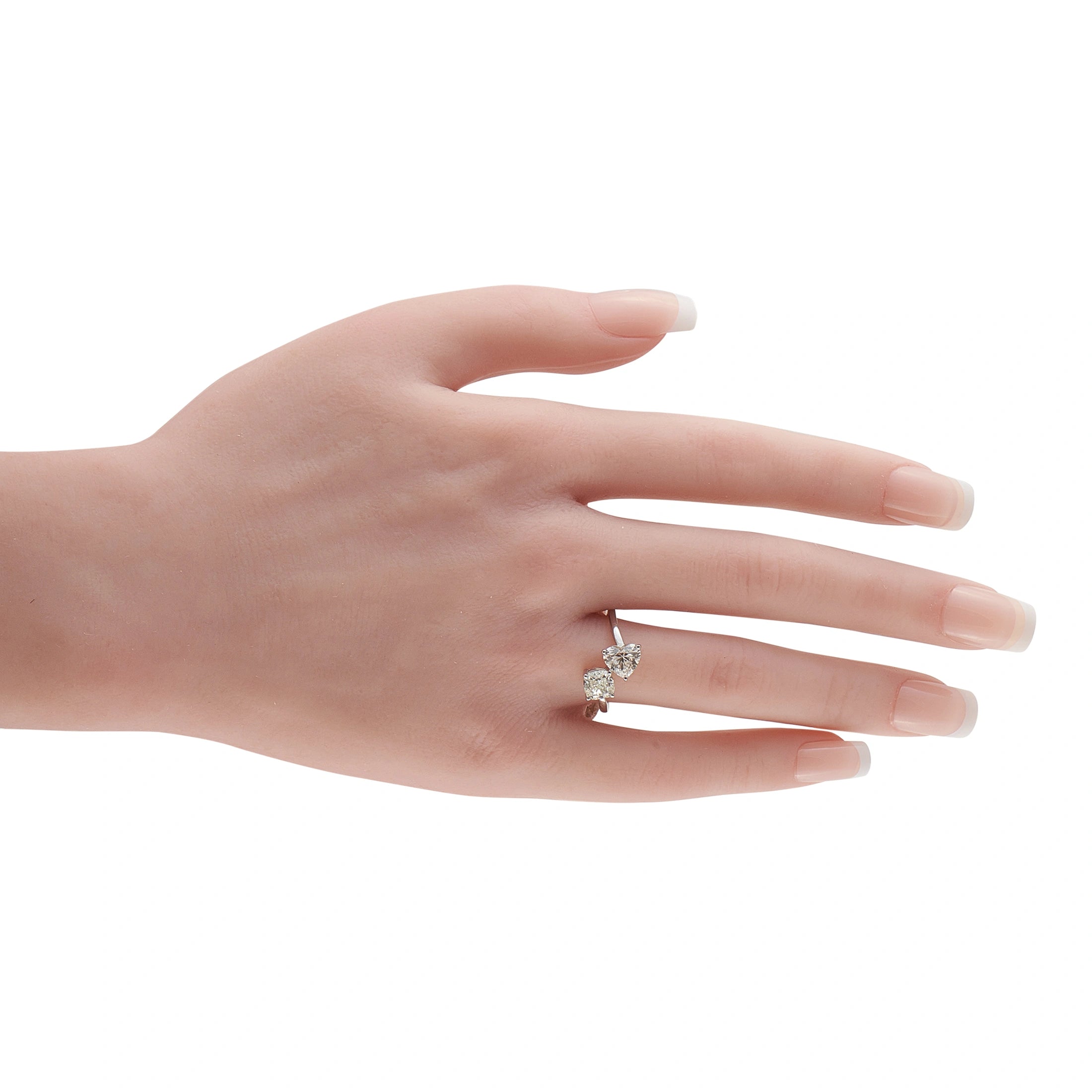 Platinum toi et moi diamond ring on hand, two prong-set stones