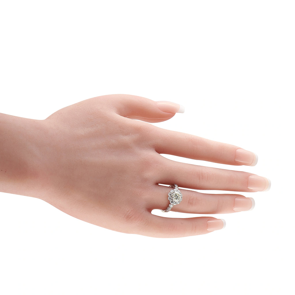 Platinum diamond ring worn on a finger, with a prominent center stone and halo