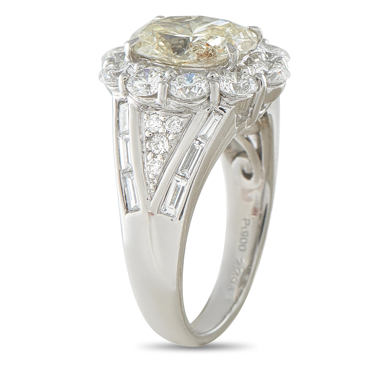 Diamond ring side view showing a raised halo setting and baguette stones along split shoulders