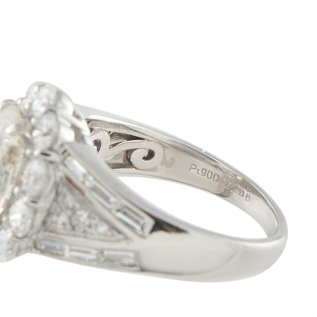 Platinum ring close-up showing engraved inner band and baguette-set split shoulders