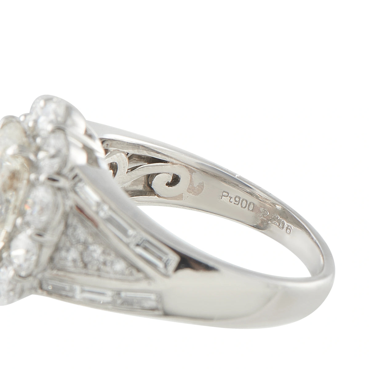 Platinum ring close-up showing engraved inner band and baguette-set split shoulders