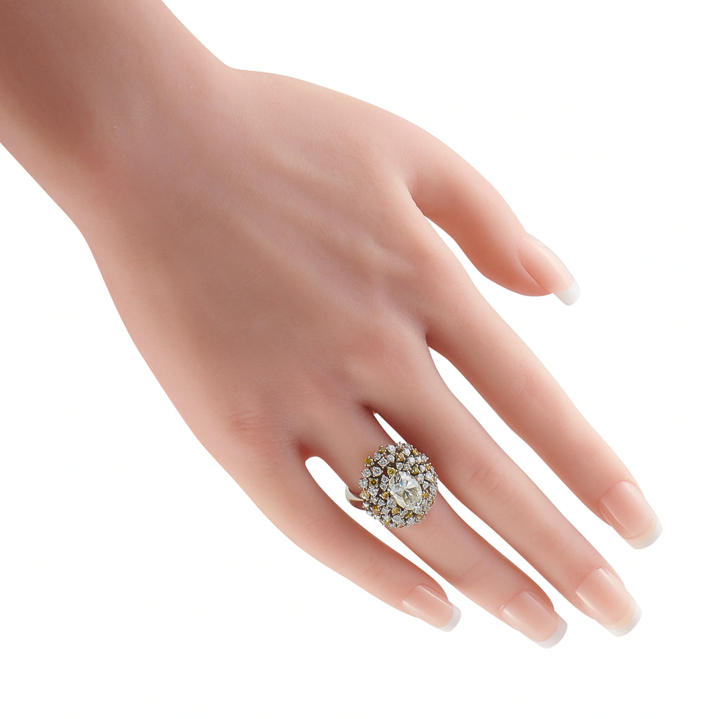 Platinum diamond ring worn on a hand, with a prominent cluster setting
