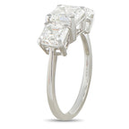 Platinum diamond ring with three stacked emerald-cut stones, side view