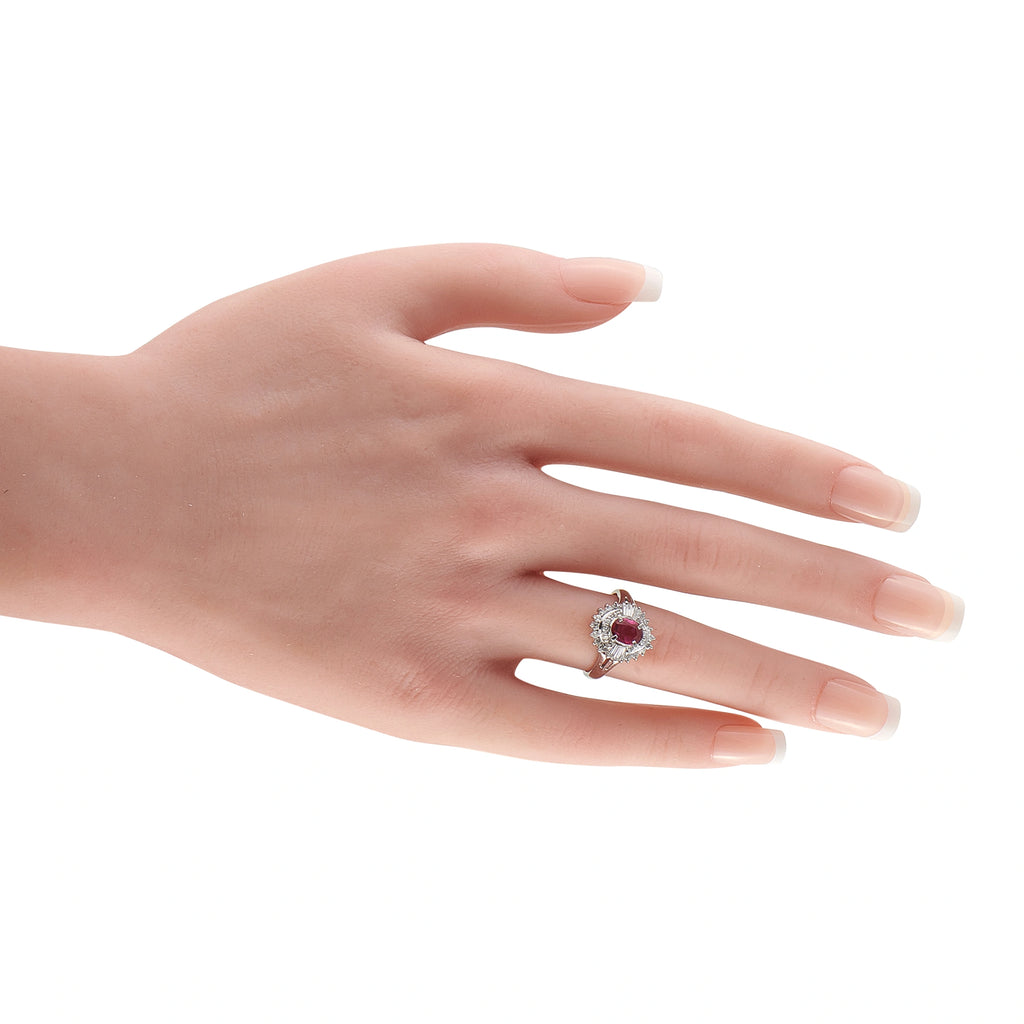 Diamond and ruby cocktail ring on finger, oval ruby center with diamond halo