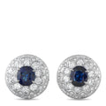 Platinum earrings with blue center stone and diamond halo, round stud design