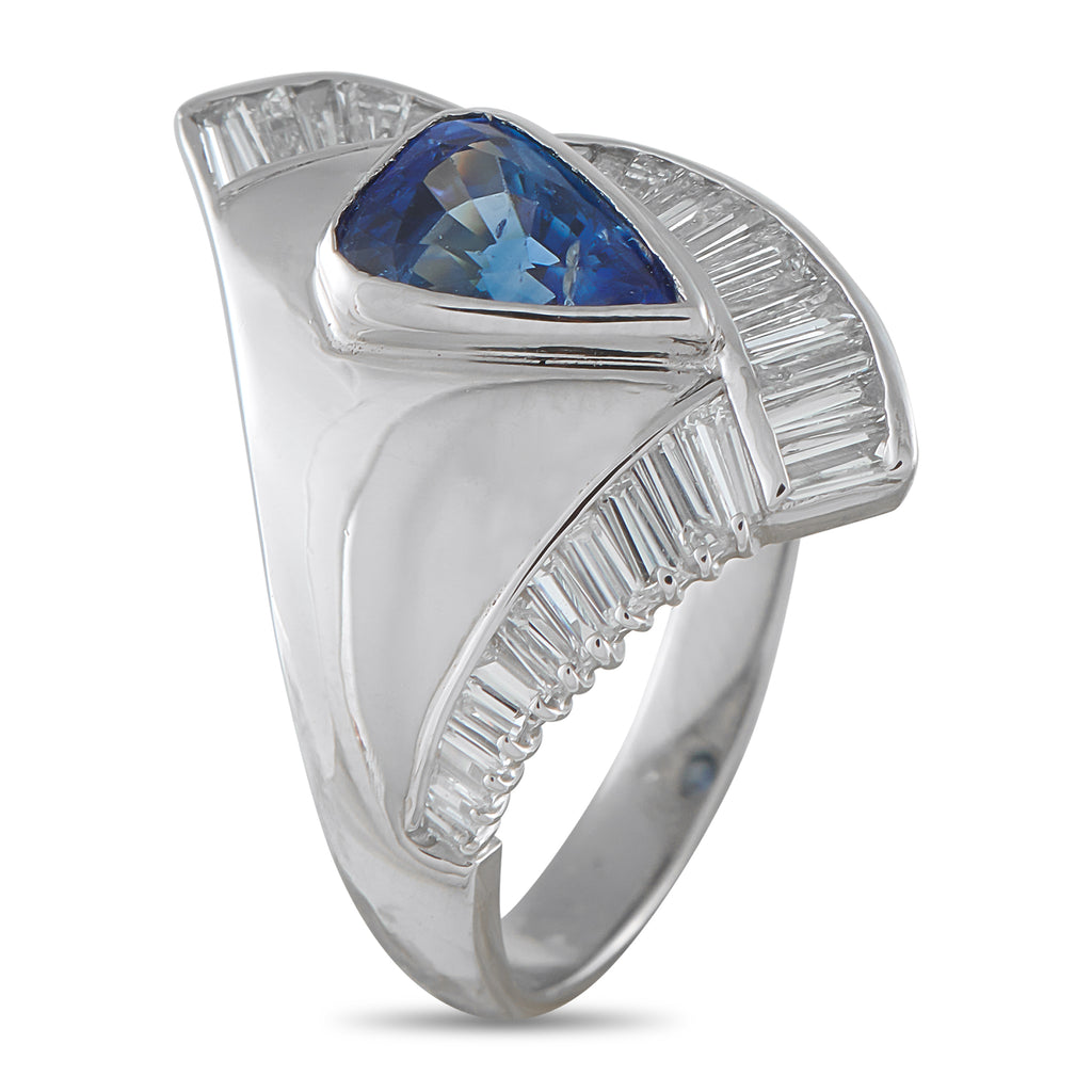 Platinum-tone statement ring with large blue sapphire and diamond baguette side settings