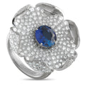 Platinum flower ring with diamond petals and a round blue sapphire center